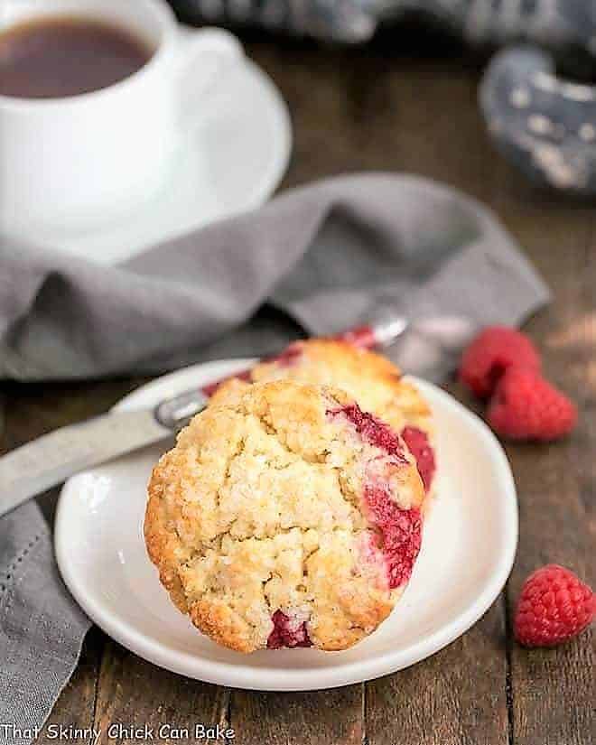 Raspberry Cream Scones - terrific, tender scones studded with fresh raspberries Raspberry Cream Scones on a round white plate with a cup of tea