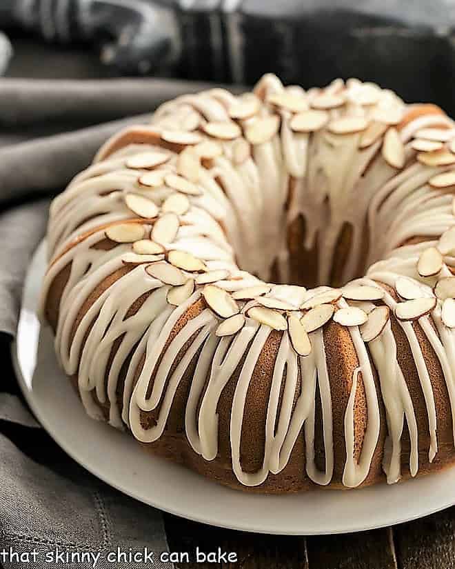 Easy Almond Bundt Cake with Amaretto Glaze - a super easy, semi-homemade cake that tastes like it's made from scratch Easy Almond Bundt Cake with Amaretto Glaze on a white serving plate