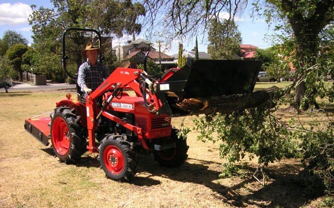 A Kubota L1501DT 18hp diesel 4WD with 4-in-1 front end loader in action.