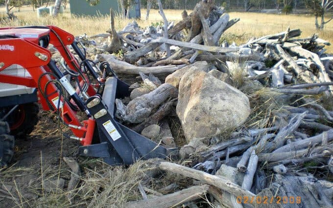 Clearing a pile of logs and rocks for the water tank site.