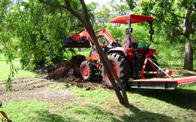 Paul spreads mulch on the garden with the APOLLO's 4-in-1 front end loader.