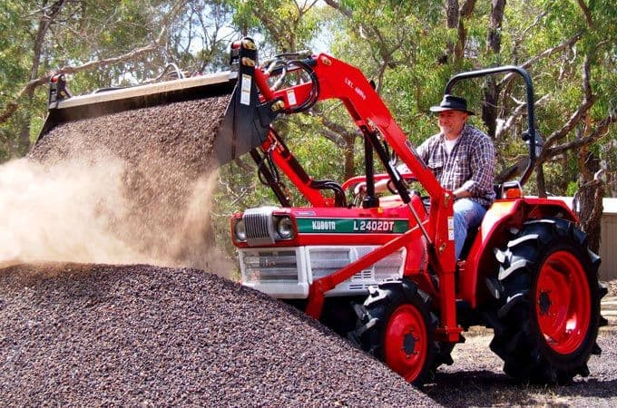Kubota L2402DT transporting gravel with an AGMAX front end loader.