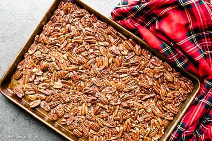Prep shot of brown butter roasted pecans in a single layer on a rimmed baking sheet.