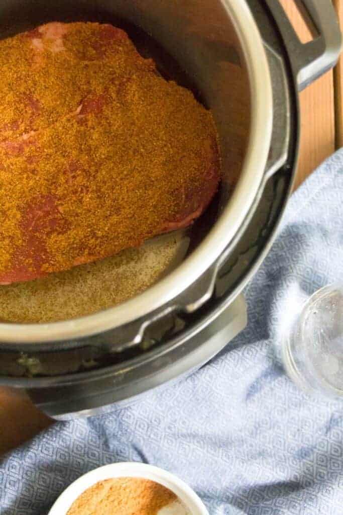 An overhead shot of a seasoned beef roast in an instant pot