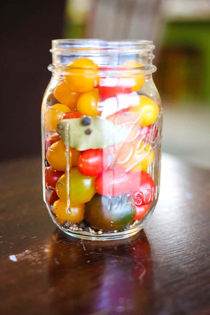 pickled cherry tomatoes in jar with spices