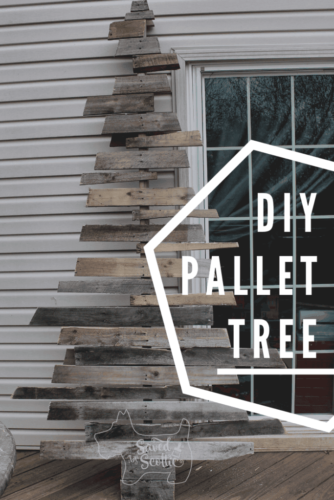 a pinnable image of the wood pallet christmas tree leaning on the siding of a house next to a glass door with wording stating DIY pallet tree