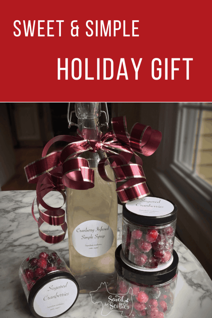 Pinnable image for sweet and simple holiday gift showing a bottle of cranberry infused simple syrup with jars of sugared cranberries around it on a marble table top.