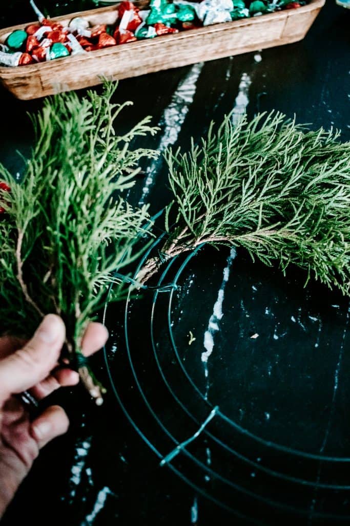 Learn how to make a real diy evergreen wreath for Christmas! This one only takes about ten minutes to make and is practically free! #christmas #christmasdecor #christmascrafts #wreath