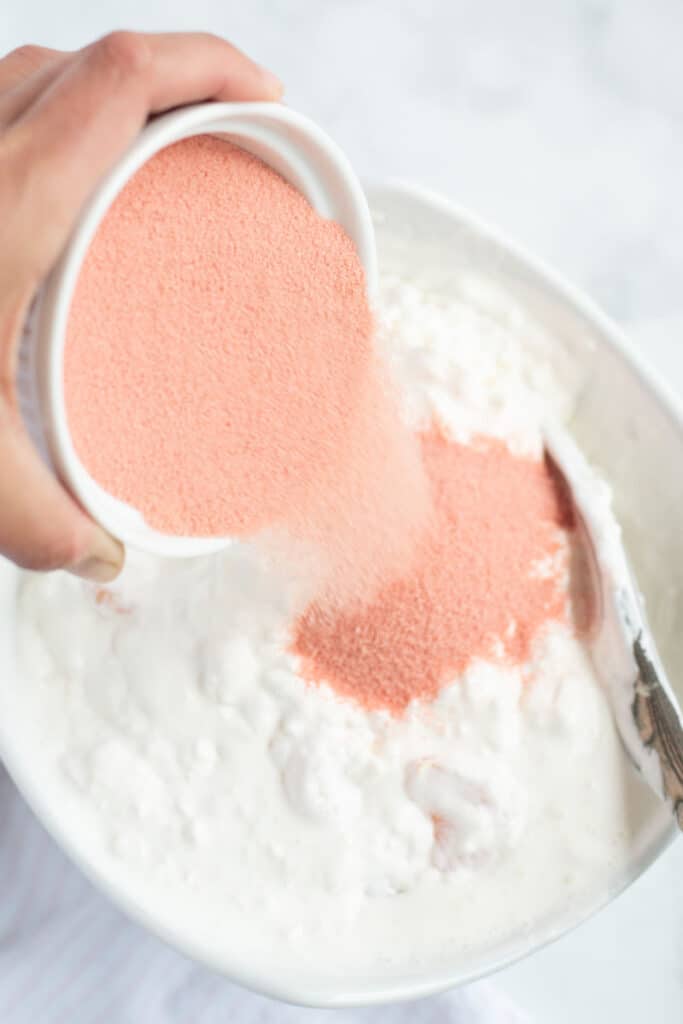 pouring dry jello into bowl to make pink salad