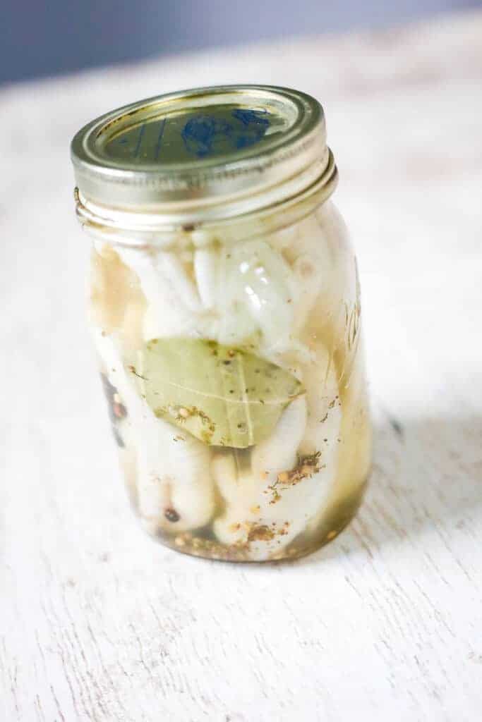 pickled chicken feet in a ball mason jar on a table
