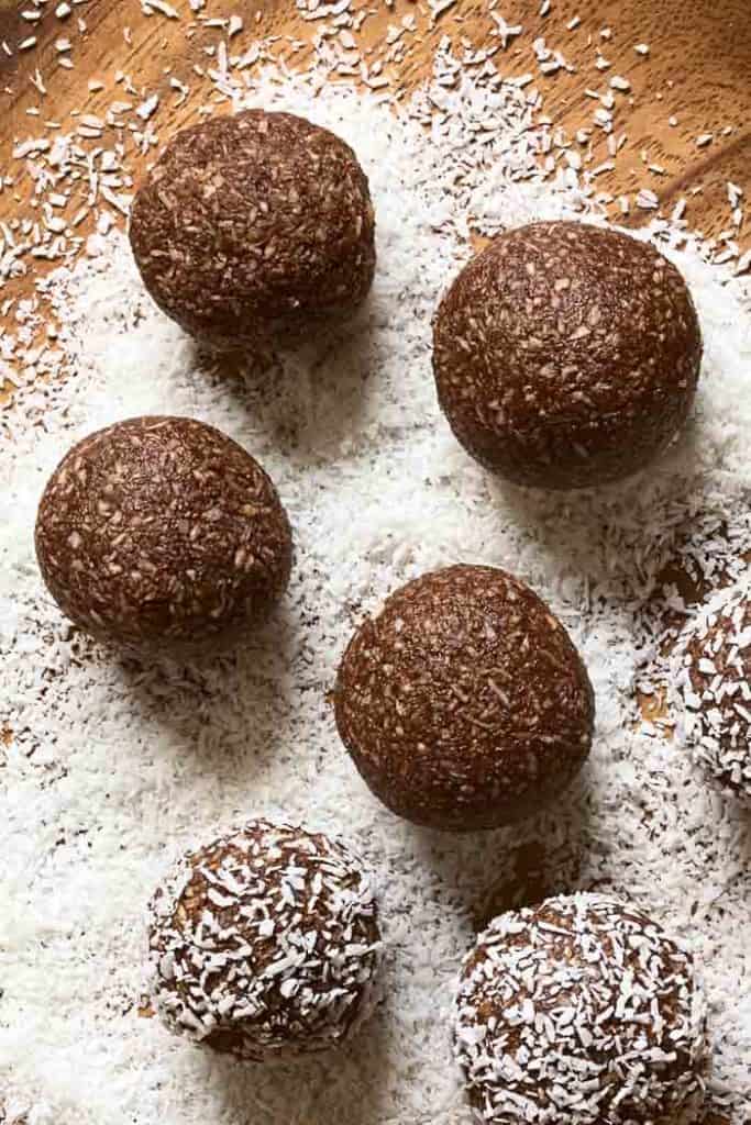 Coconut Rum Balls Coconut rum balls being rolled and coated in coconut