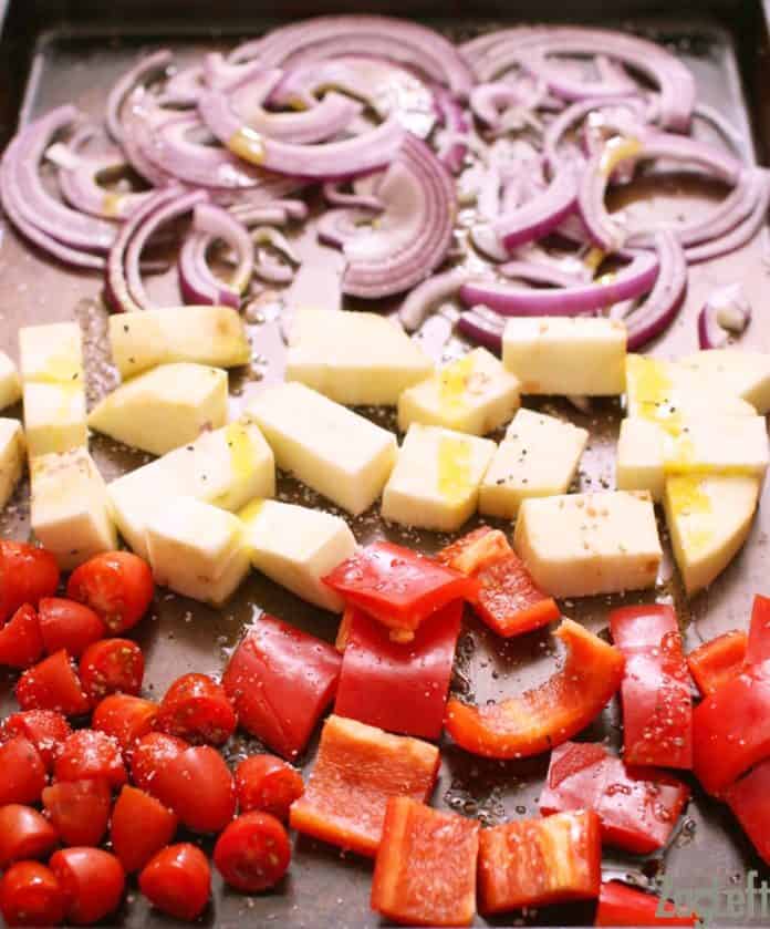 Roasted red onions, eggplant, red pepper, and cherry tomatoes with olive oil and seasoned on a baking sheet