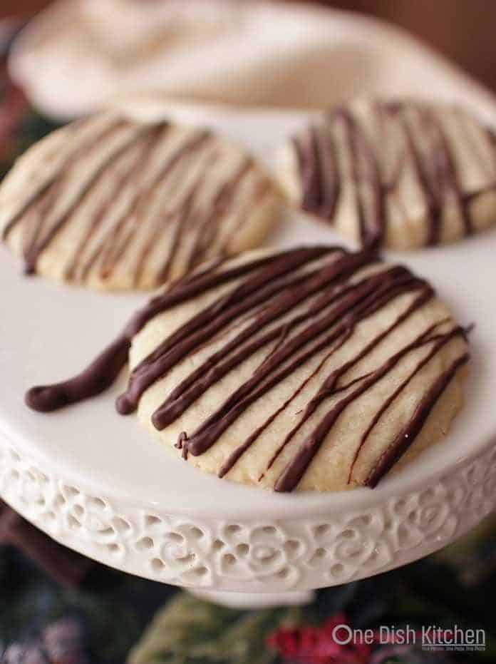 A plate of three shortbread cookies drizzled with melted chocolate