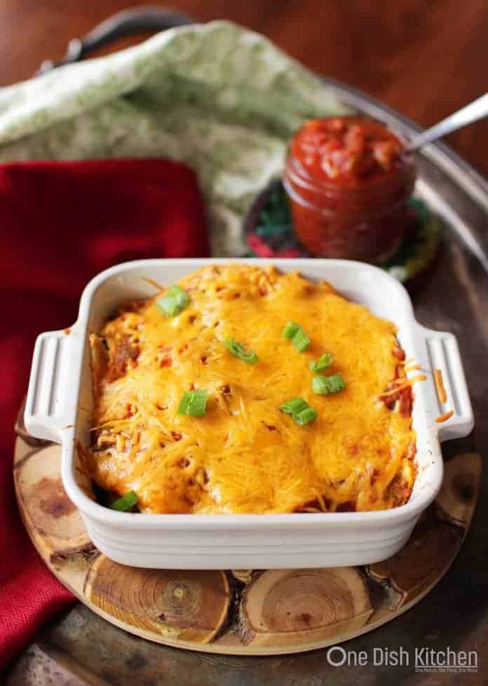 Vegetarian enchiladas topped with melted cheese in a small baking dish.