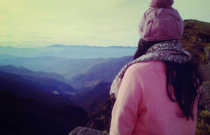 A girl looking mountains from Tungnath in Chopta Valley during summer season A girl looking mountains from Tungnath in Chopta Valley during summer season