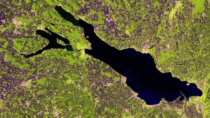 This satellite image of Lake Constance was acquired on May 10, 2014 in ‘interferometric wide swath mode’ and in dual polarization. The radar instrument gathers information in either horizontal or vertical radar pulses, and colors were assigned to the different types. In this image, buildings generally appear pink, while vegetation is green. Areas with lowest reflectivity in all polarisations appear very dark, like the water. Source: ESA.