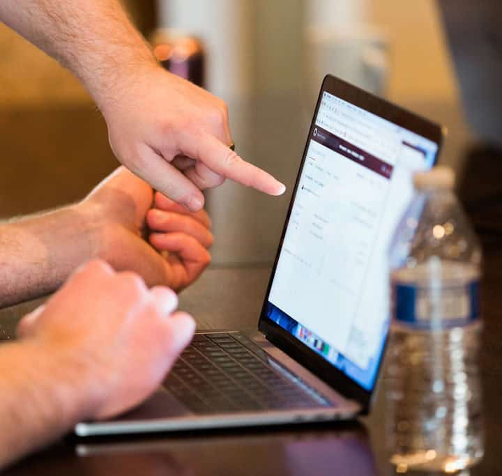 Hands pointing to a laptop