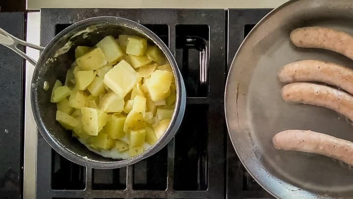 Overhead shot of cooked and drained Yukon gold potatoes with a chunk of butter melting on top.