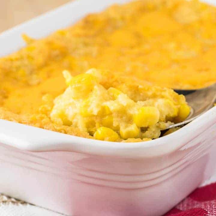 white baking dish with baked corn casserole sitting on kitchen towel