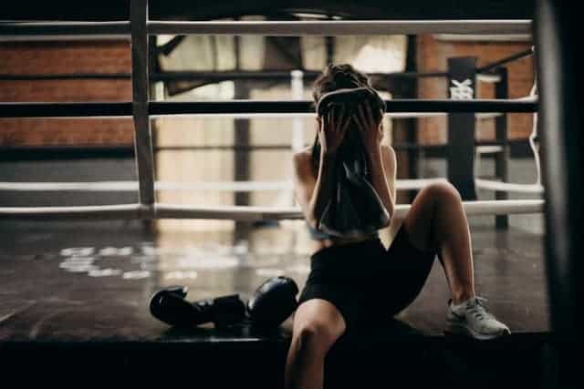 donna si asciuga il sudore dal viso dopo un allenamento faticoso