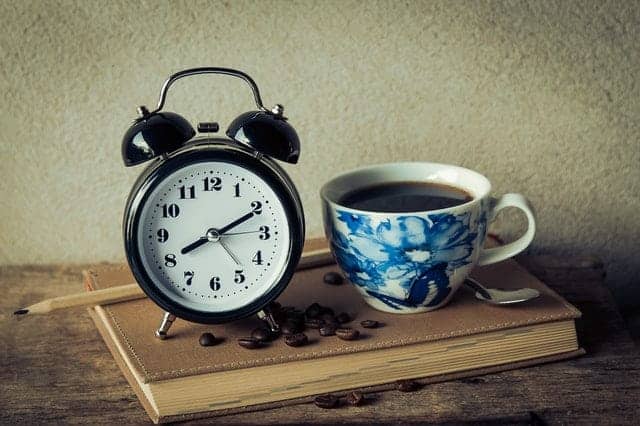 een kop koffie en een wekker
