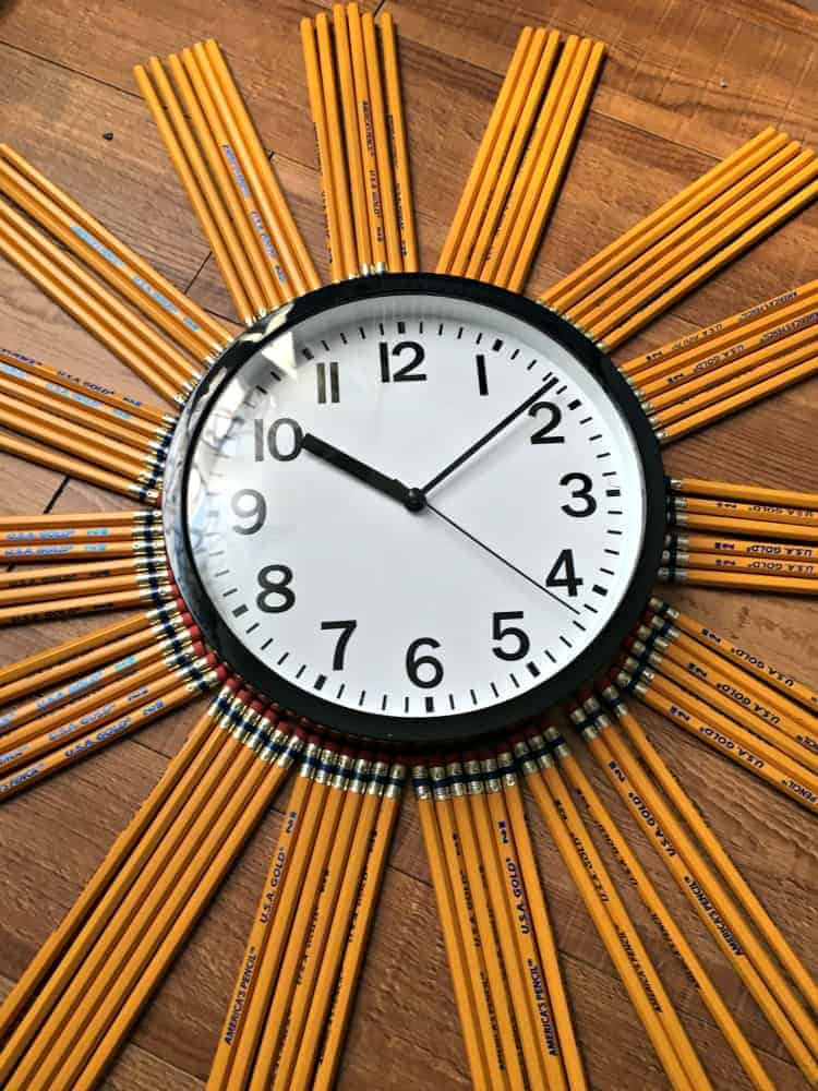 school clock with pencils around it grouped together