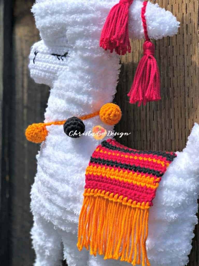 picture of fuzzy llama with orange and black baubles