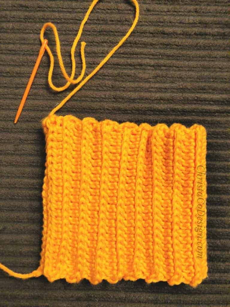 picture of folding and seaming orange crochet rectangle for pumpkin hat