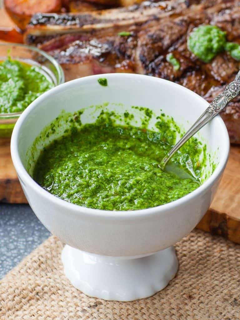 creamy avocado chimichurri sauce in white bowl with steak