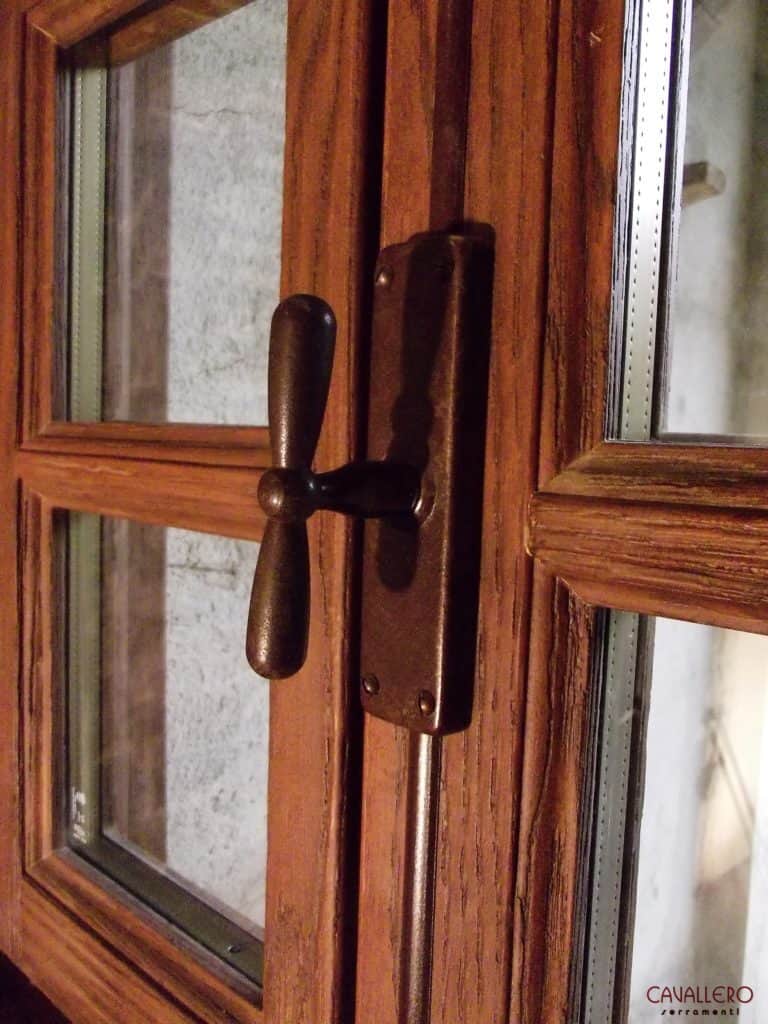 Dettaglio della finitura rusticata del legno e della martellina ad aste esterne in ferro anticato