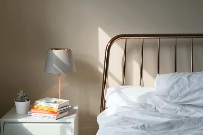 A peaceful bed and nightstand vignette - essential for reducing anxiety at night and getting better sleep