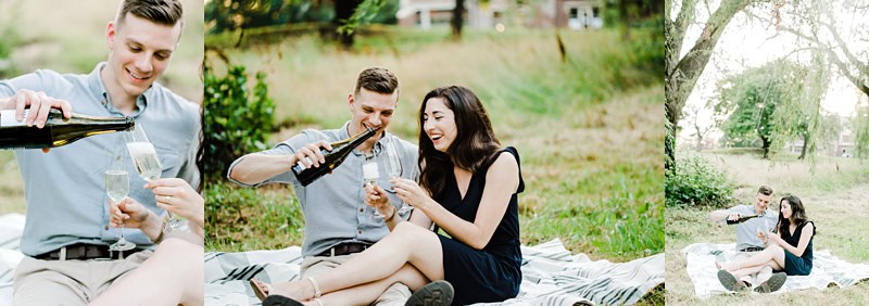 mayslake peabody estate engagement session couple sitting on the ground opening bottle of champagne
