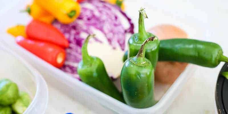 fresh jalapenos in tupperware ready to be quick pickled