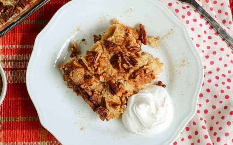 pumpkin pecan cobbler on a white plate with cream
