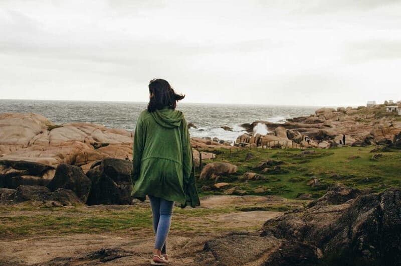 Woman walking by the sea. Photo by Paz Arando on Unsplash