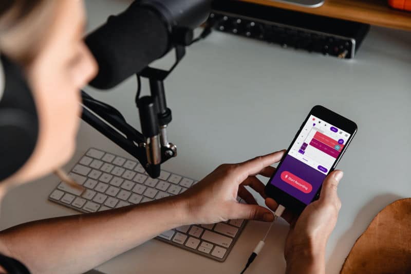 Person recording a podcast. Photo by Soundtrap on Unsplash