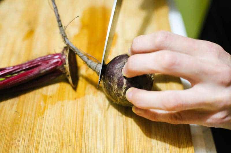 someone cutting a beet to pickle it