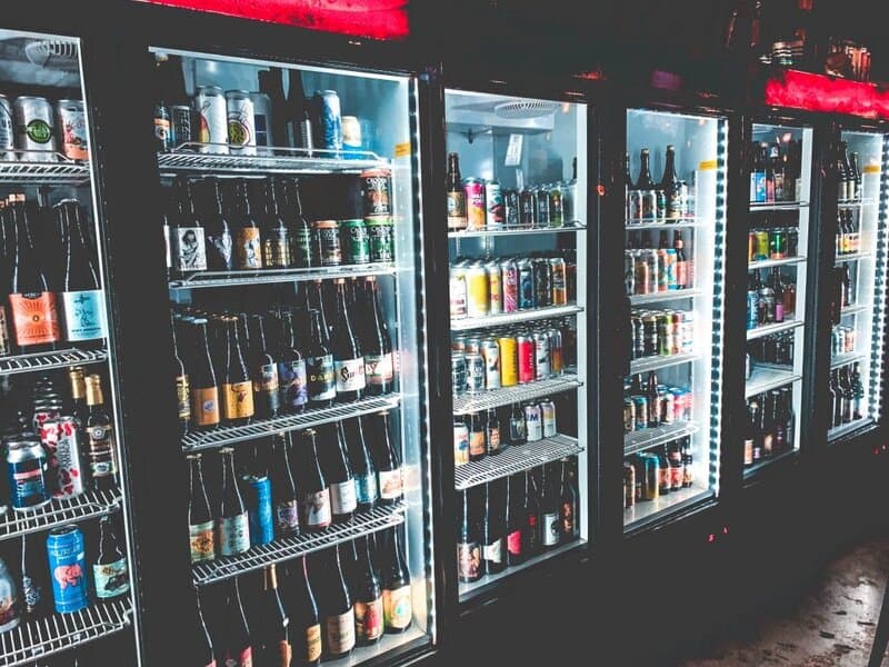 A photo of fridges filled with drinks. Photo by Justin Sanchez on Unsplash