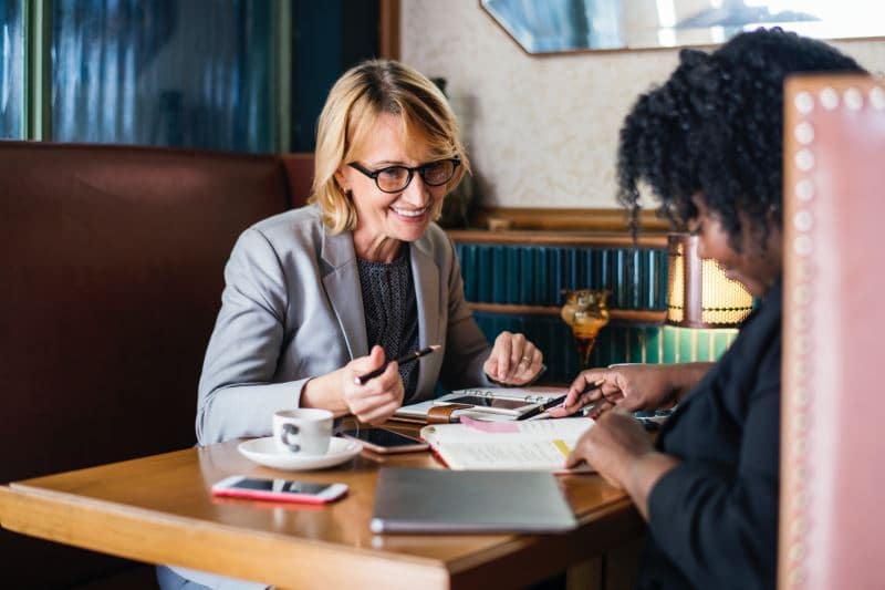 A photo of two people working across a table