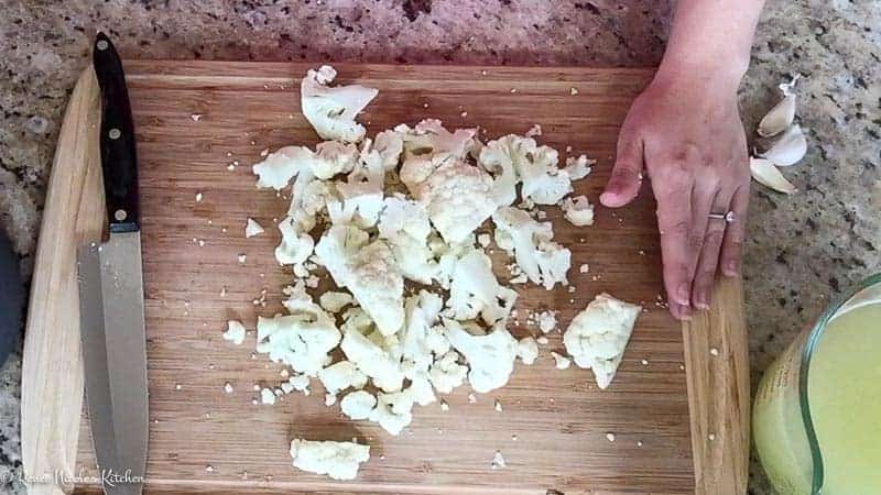 Chopped up cauliflower on a cutting board.