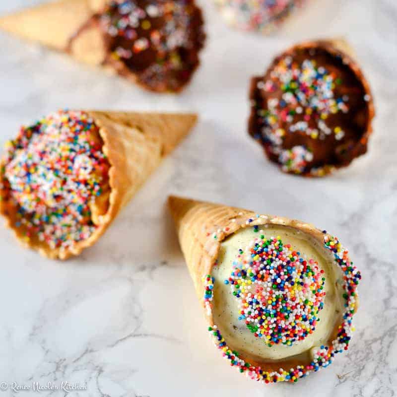 Angled shot of 6 cones, two in chocolate, two peanut butter, two vanilla.