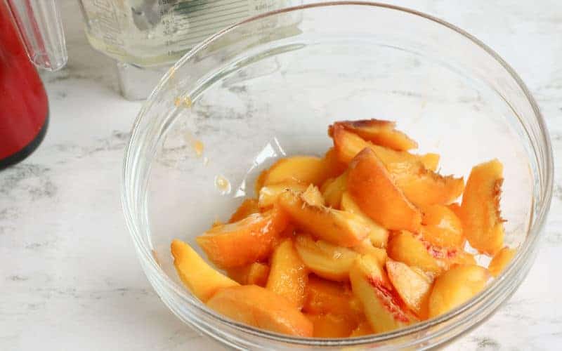 peaches in a clear bowl to be used for peach sorbet homemade ice cream