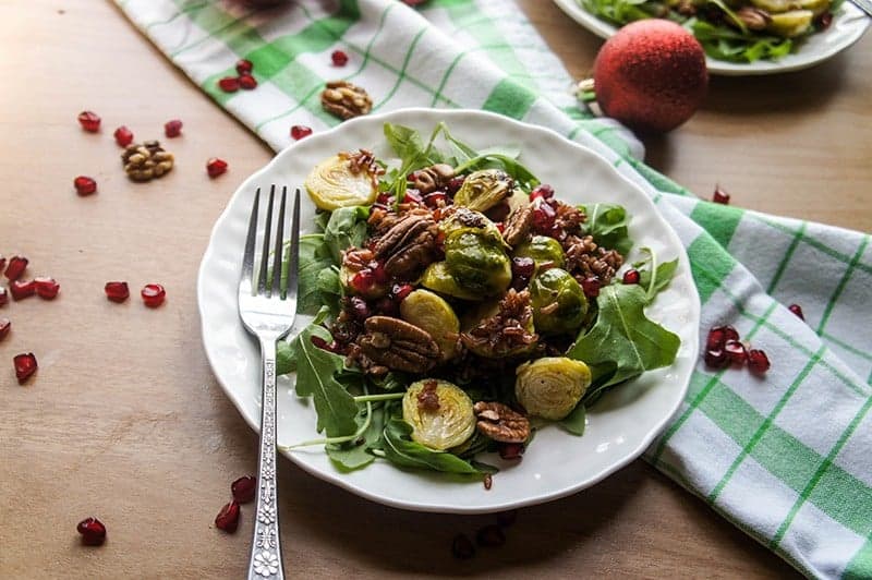 Warm Winter Salad / Red rice, arugula, and roasted brussels sprouts make this warm salad a holiday treat. Topped with pecans and pomegranate for a festive combination.