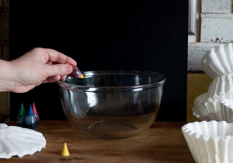 Adding yellow food coloring to glass bowl