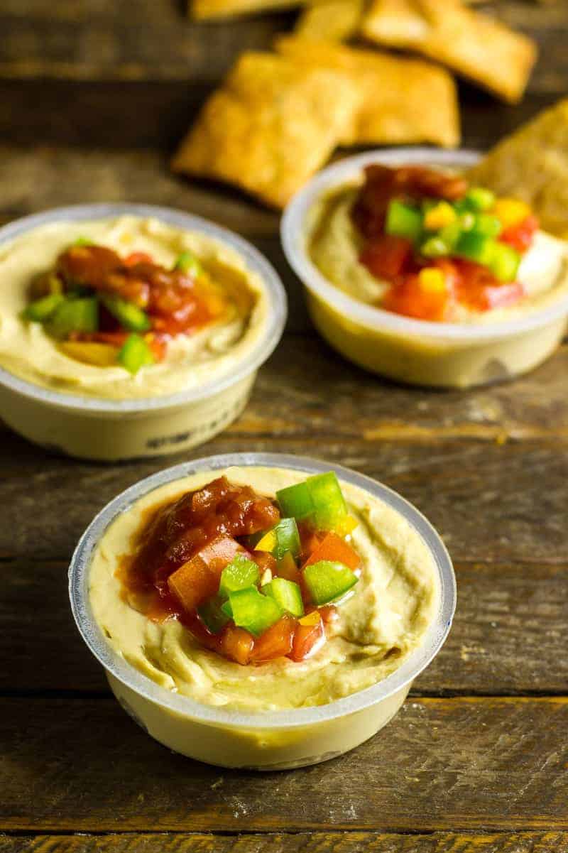 Hummus Dip with Salsa & Fresh Veggies Individual Hummus Dip with Fresh Veggies next to a pile of pita chips