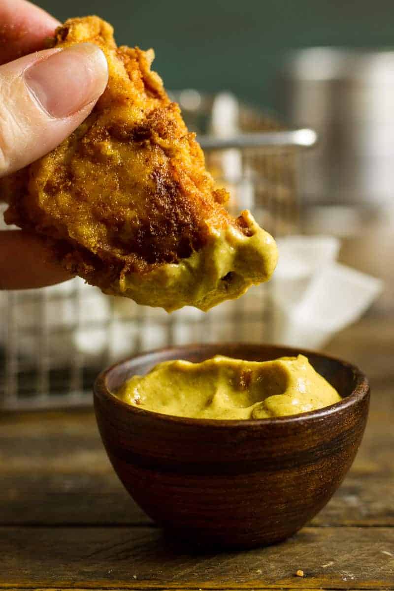 Pickle-Brined Keto Fried Chicken Pickle Brined Keto Fried Chicken in a basket with brown parchment paper and a pickle spear and some garlic mustard aioli.