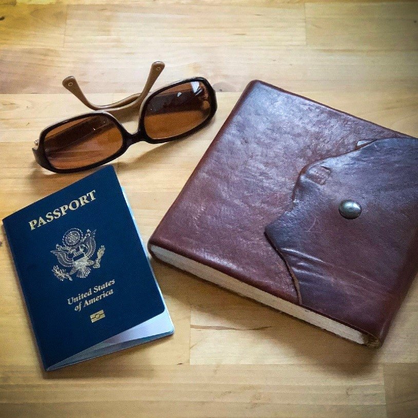passport, journal, and sunglasses for minimalistic travel