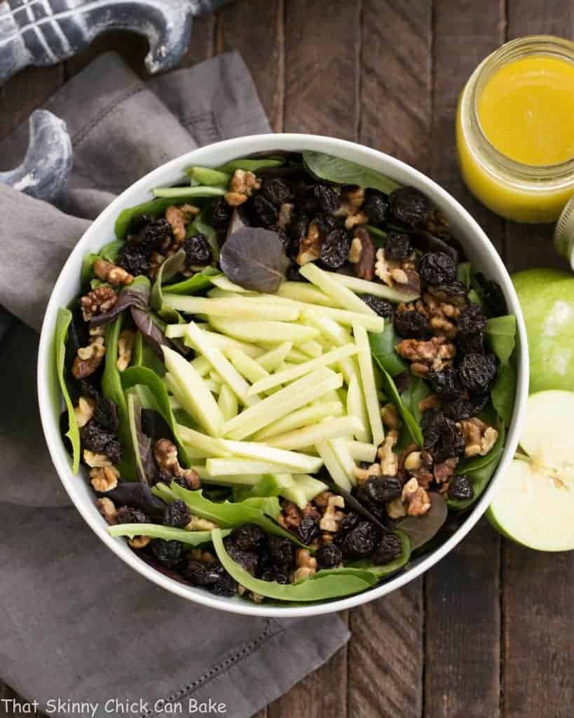 Apple, Cherry, Walnut Salad with Maple Dressing - A fabulous fall/winter salad that always gets rave reviews! Apple, Cherry, Walnut Salad with Maple Dressing overhead view with halved apple and dressing in a jar