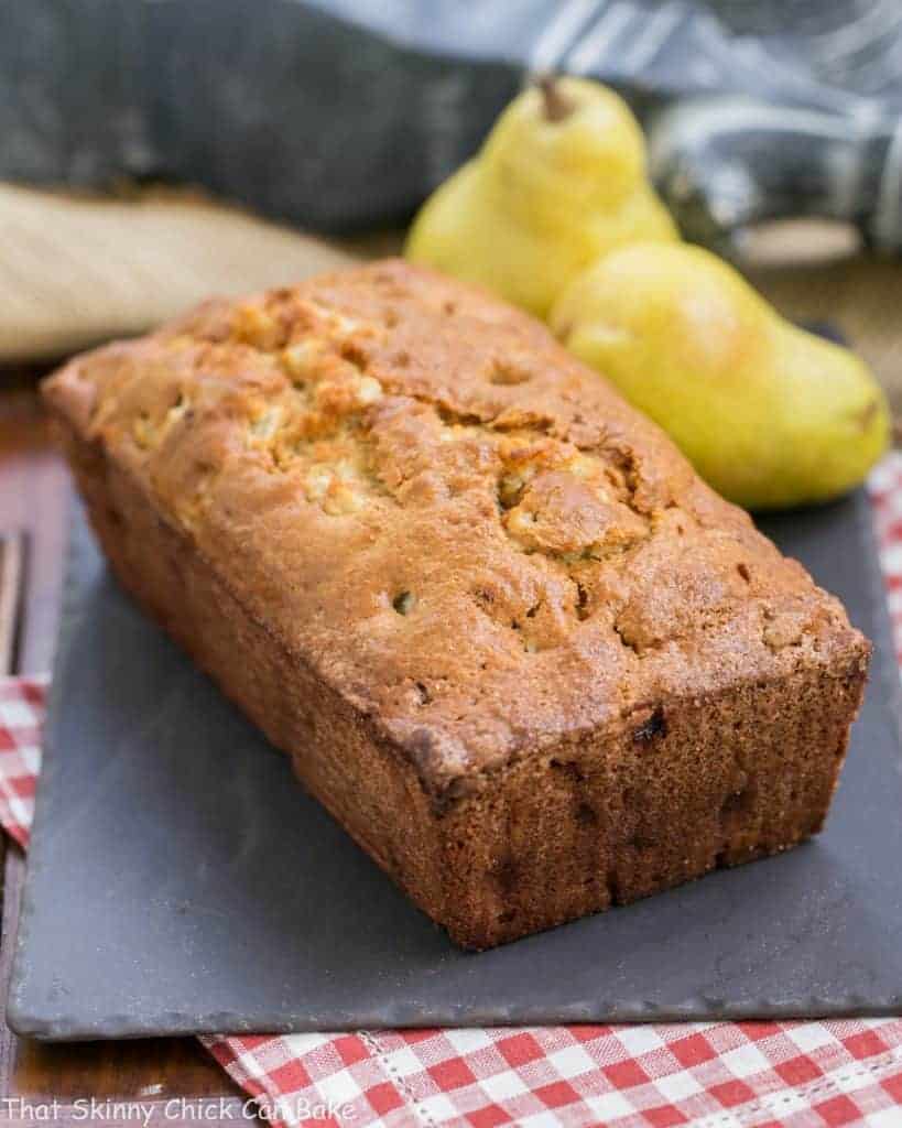 Sour Cream Pear Bread - A delectable autumn quick bread with subtle warm spices and chunks of fresh pears Loaf of Sour Cream Pear Bread on a slate board