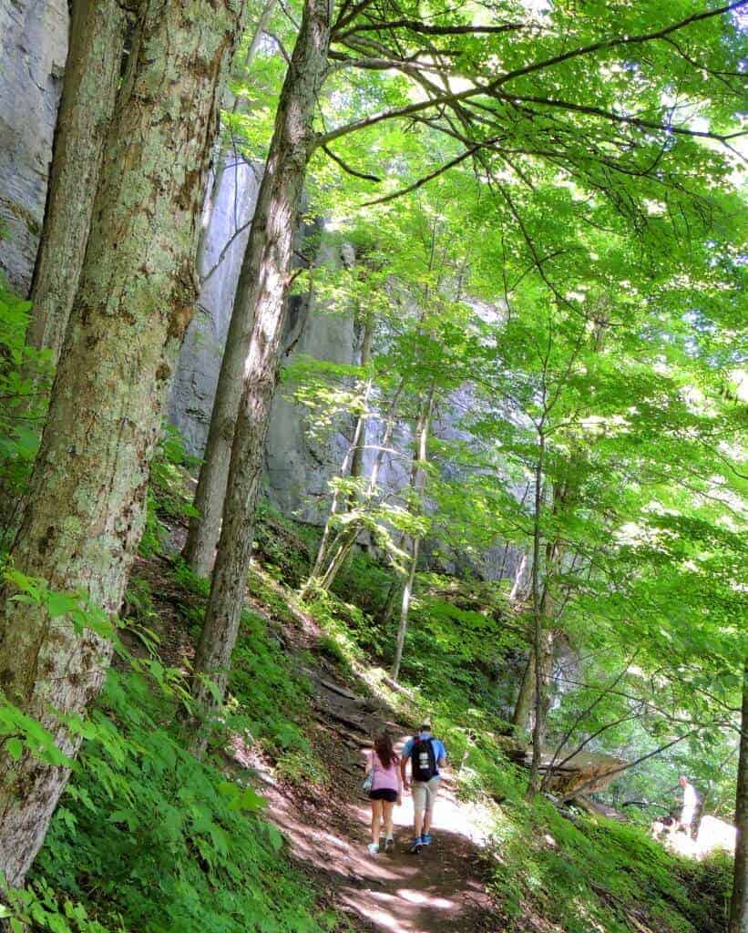 Super awesome couples road trip ideas A couple hikes through the woods in a New York State Park